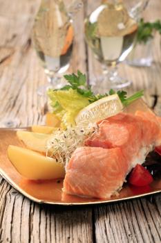 Salmon fillet served with potatoes and vegetable garnish