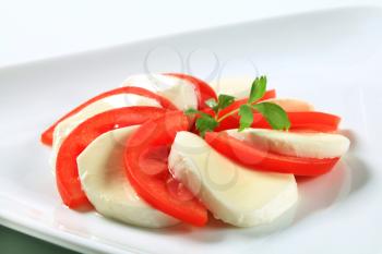 Slices of mozzarella cheese and fresh tomato 
