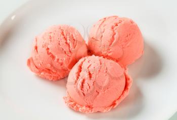 Scoops of strawberry ice cream on plate