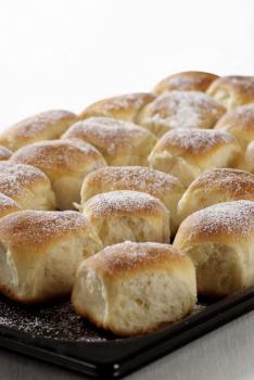 Sweet yeast buns on a baking tin