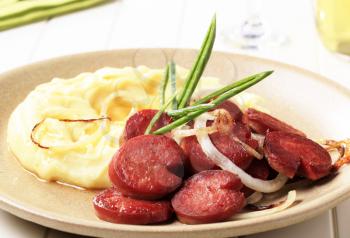 Mashed potato and slices of pan-roasted wurst