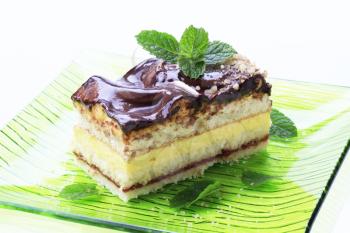 Slice of cream cake topped with chocolate sauce