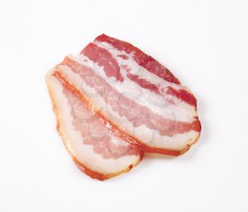 Slices of cured bacon on white background