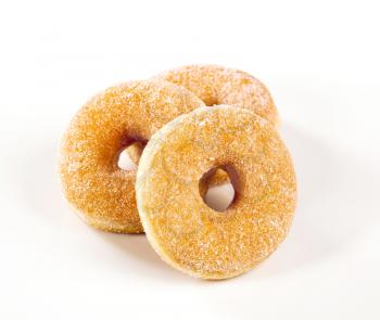 Studio shot of three fresh sugared donuts
