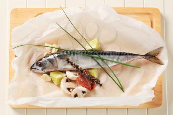 Raw mackerel and vegetables on parchment paper