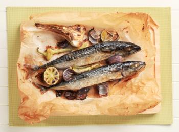 Baked mackerel and vegetables on parchment paper