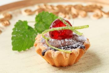 Chocolate filled tartlet topped with maraschino cherry