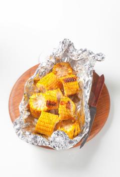 Pieces of grilled sweet corn in tin foil