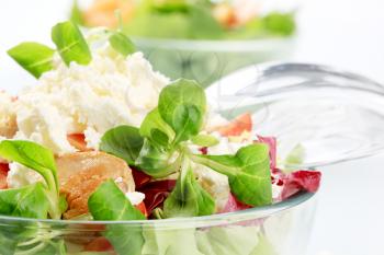 Bowl of salad greens with chicken meat and feta