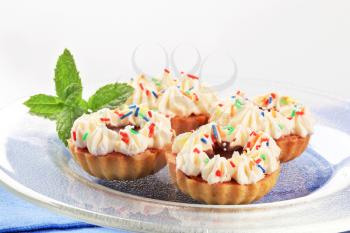 Chocolate and cream tartlets decorated with sprinkles