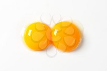 Two raw egg yolks on white background
