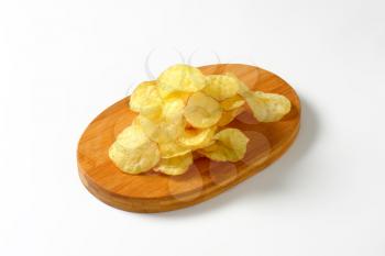 Heap of potato chips on a cutting board