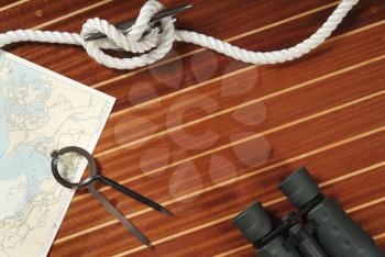 Nautical divider on a chart, rope and binoculars 