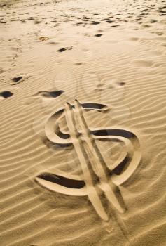 Dollar sign drawn in the sand - closeup