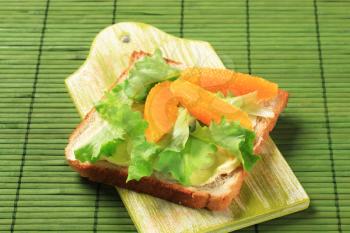 Sandwich bread with lettuce and wedges of orange