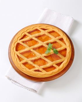 Lattice topped apricot tart on cutting board