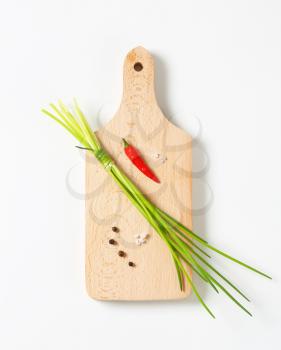 Bunch of fresh chives and other ingredients on cutting board
