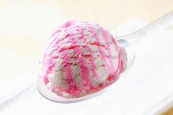 Scoop of cherry ice cream on spoon