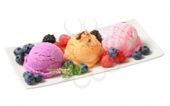 Scoops of fruit-flavored ice cream on long plate