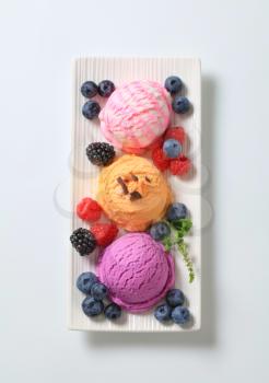 Scoops of ice cream garnished with fresh berry fruit