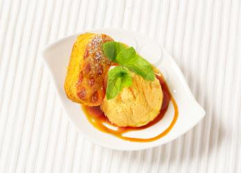 Small Dutch oval-shaped cake (Roomboter kano) with ice cream and caramel syrup