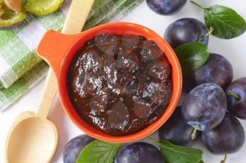 Bowl of plum preserve and fresh plums