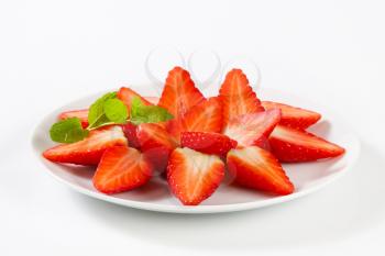 Halved strawberries arranged on plate