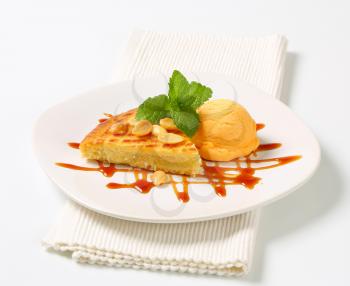 Almond cake with scoop of ice cream and caramel sauce