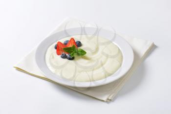 Smooth semolina porridge with fresh strawberries and blueberries