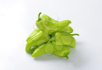 Group of raw green peppers on white background