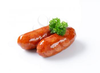 Two grilled sausages on white background