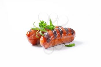two grilled sausages on white background