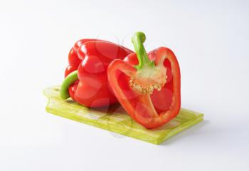 one and half red bell pepper on wooden cutting board