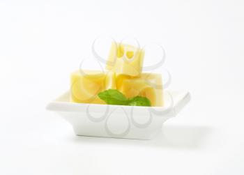 cubes of emmental cheese in white bowl
