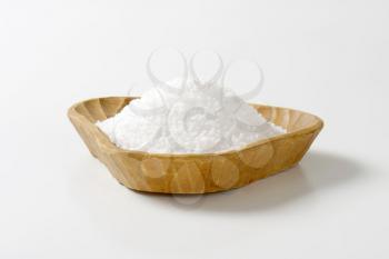 Coarse grained salt in triangle wooden bowl