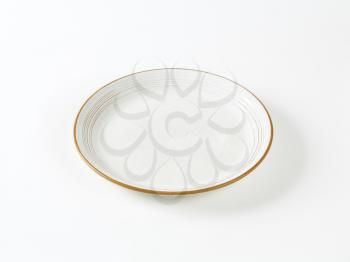 Glazed ceramic soup plate with brown trim