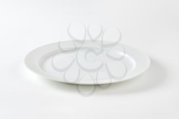 White porcelain plate with ribbed rim