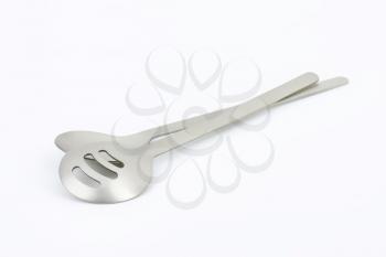 metal salad spoon and fork and green apple