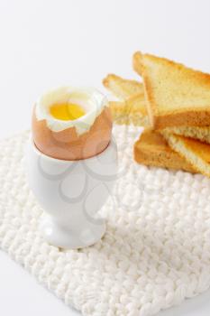 soft boiled egg in eggcup with toasted bread