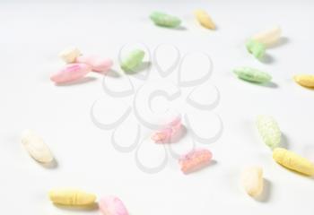 colorful puffed rice scattered on white background