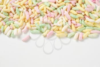 sugar coated colored puffed rice on white background
