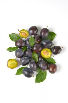 Group of ripe plums with leaves