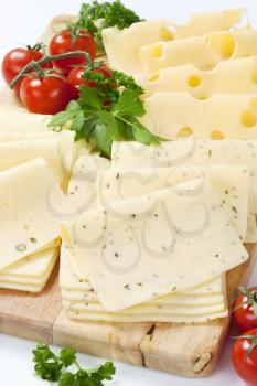 variety of sliced cheeses on cutting board