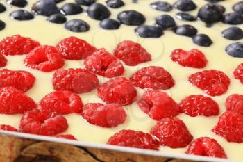 detail of sponge cake batter with raspberries and blueberries