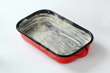 red baking pan greased with butter