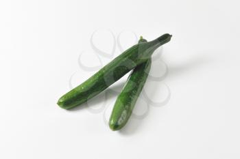 Two whole green slicing cucumbers