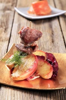 Roasted meat on stick and apple