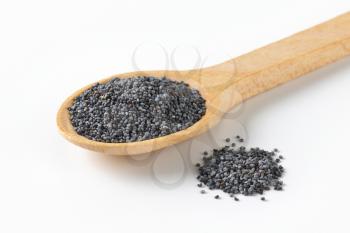 whole ripe poppy seeds on small wooden spoon