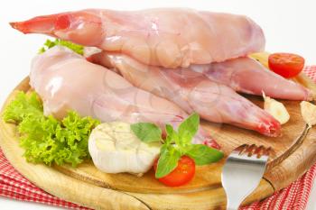 Fresh rabbit meat with raw vegetables on cutting board