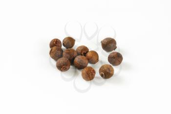 handful of allspice berries on white background